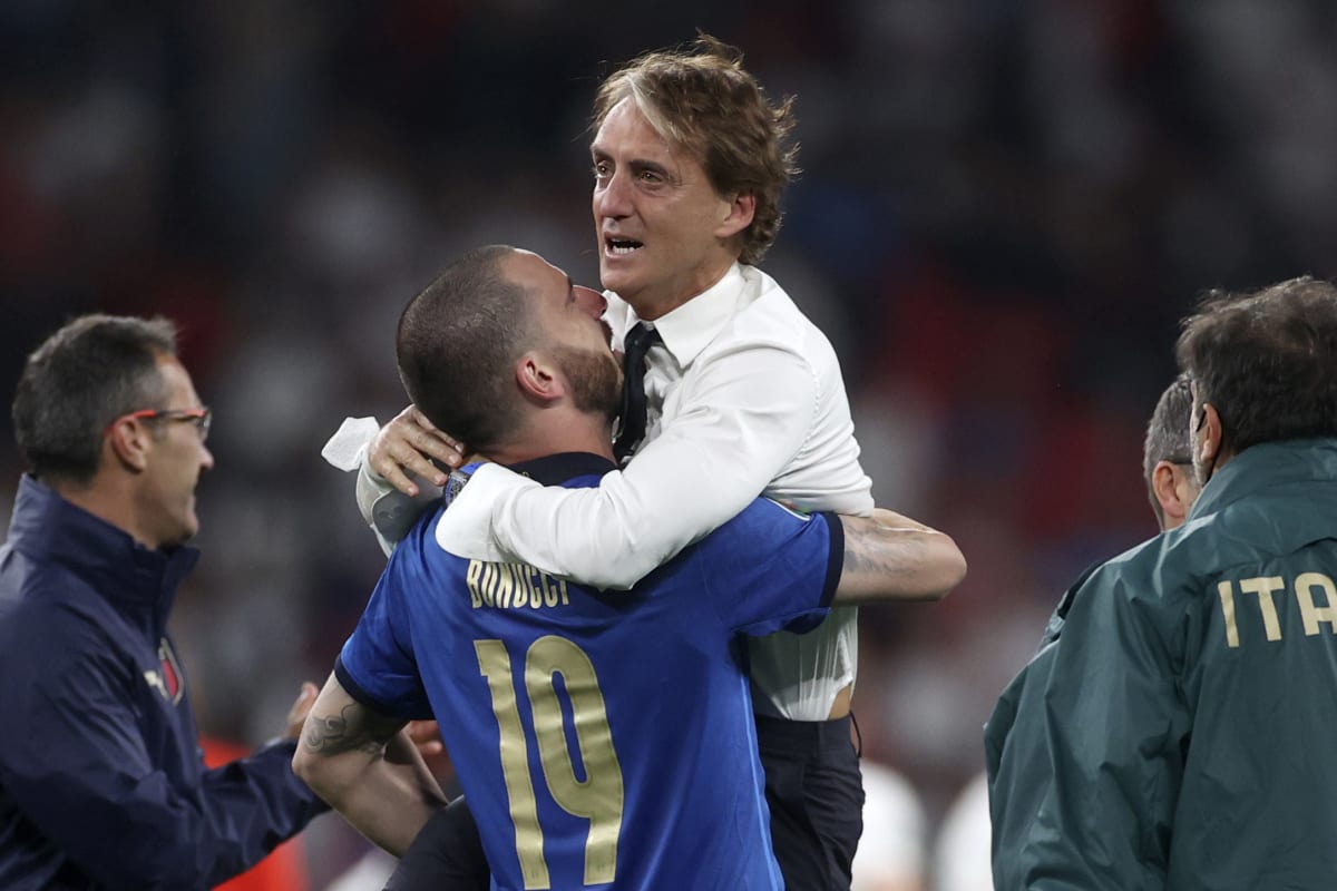 Italský obránce Leonardo Bonucci objímá a nese trenéra Roberta Manciniho po vítězství ve finále fotbalového Eura 2021. 