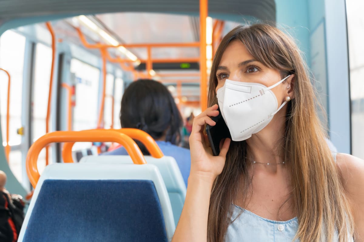 Žena s respirátorem v autobusu.