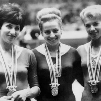 Československá gymnastka Věra Čáslavská (uprostřed) s olympijskou medailí z Tokia