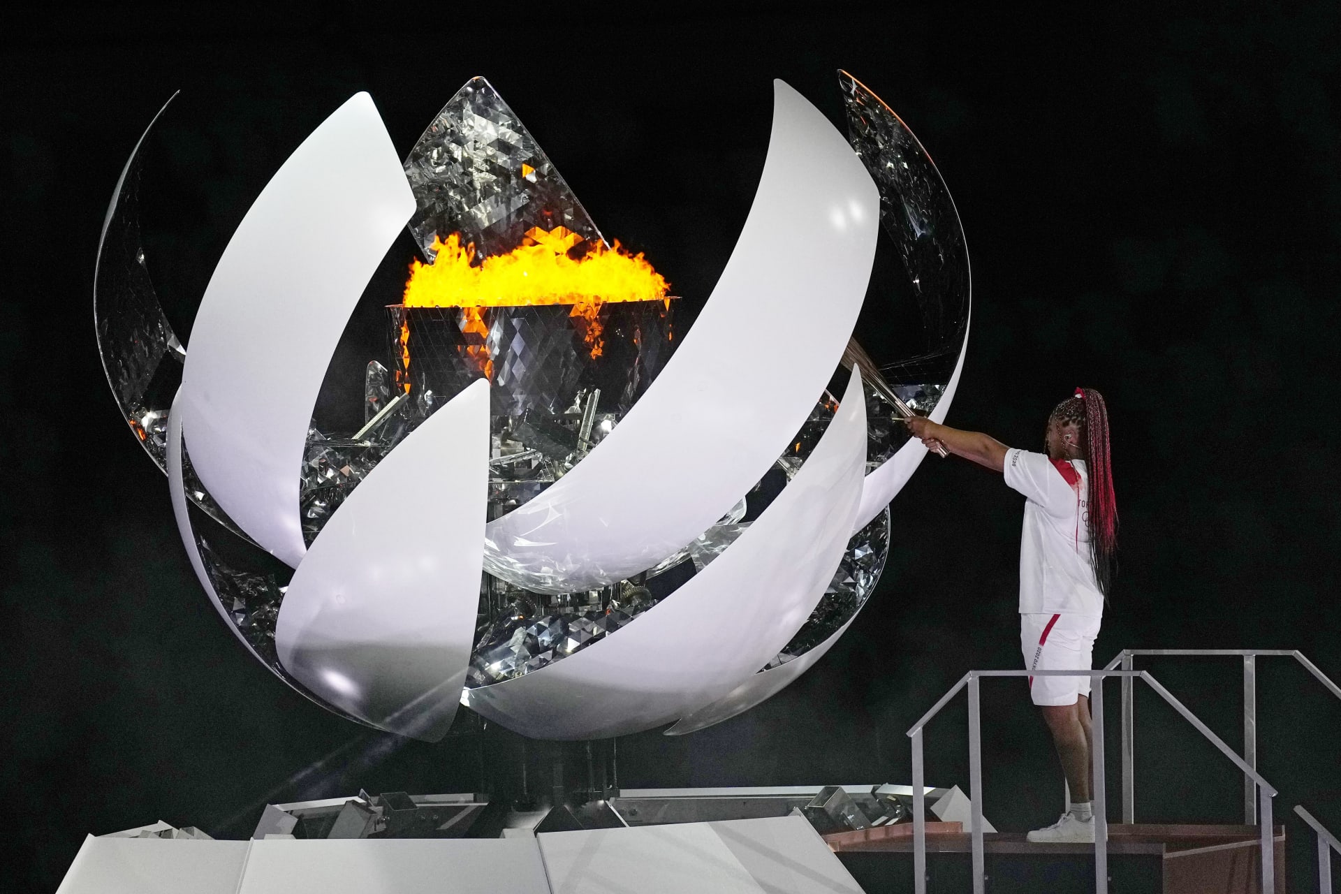 Naomi Ósakaová zapaluje olympijský oheň během zahajovacího ceremoniálu na Olympijském stadionu.