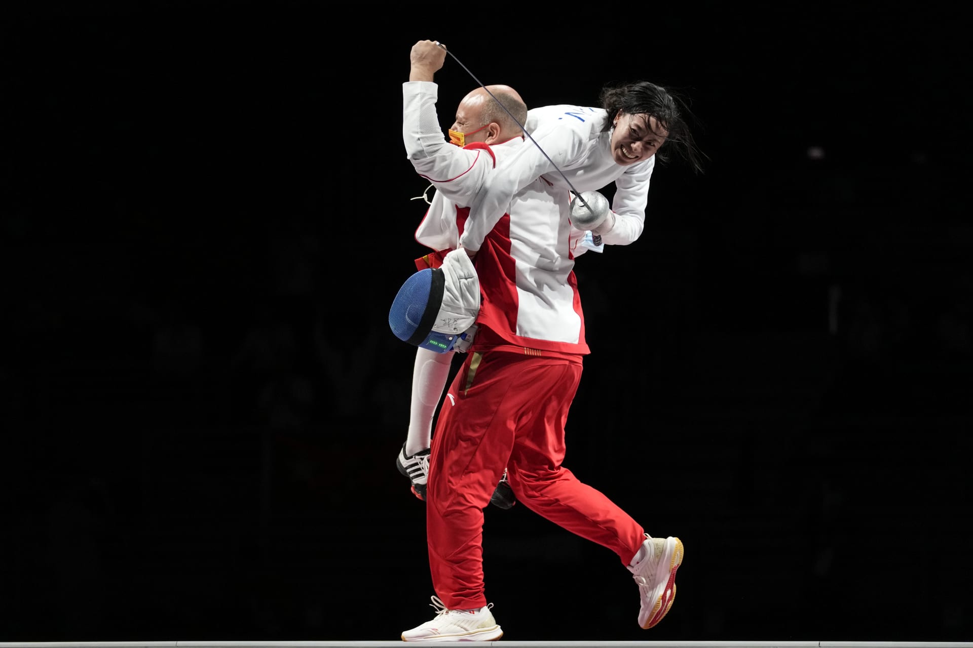 Čínská reprezentantka Sun Yiwen slaví se svým trenérem Huguesem Obrym po zisku zlaté medaile v individuálním souboji epee žen.