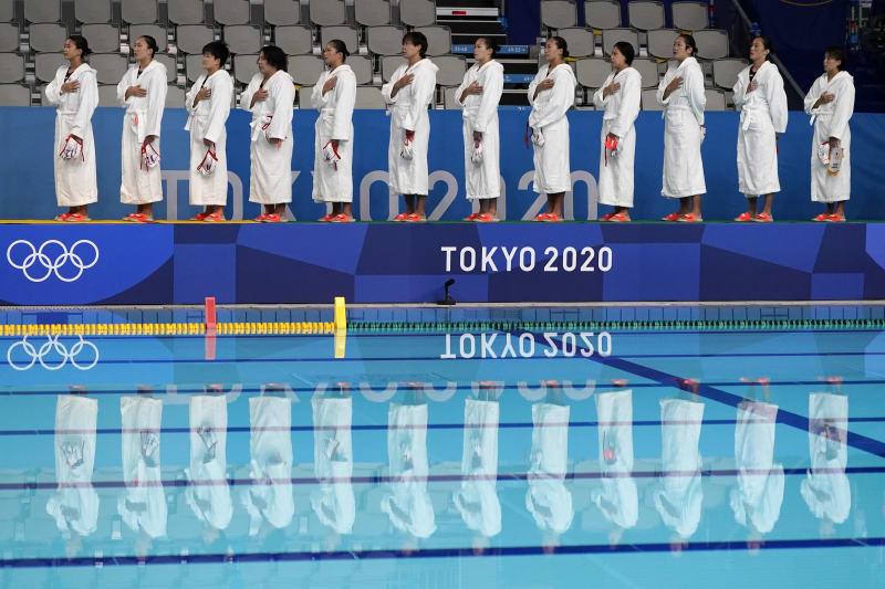 Japonský tým stojí u státní hymny před zápasem úvodního kola vodního póla žen proti Spojeným státům.