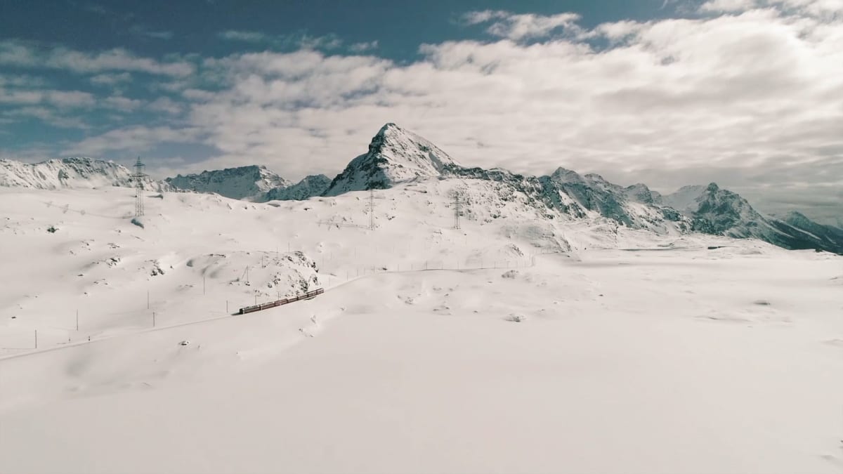 V zimě se švýcarské vlaky klikatí podél zasněšené krajiny.
