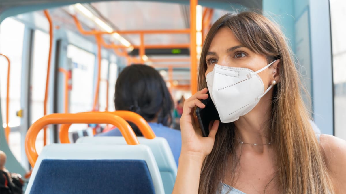 Žena s respirátorem v autobusu.
