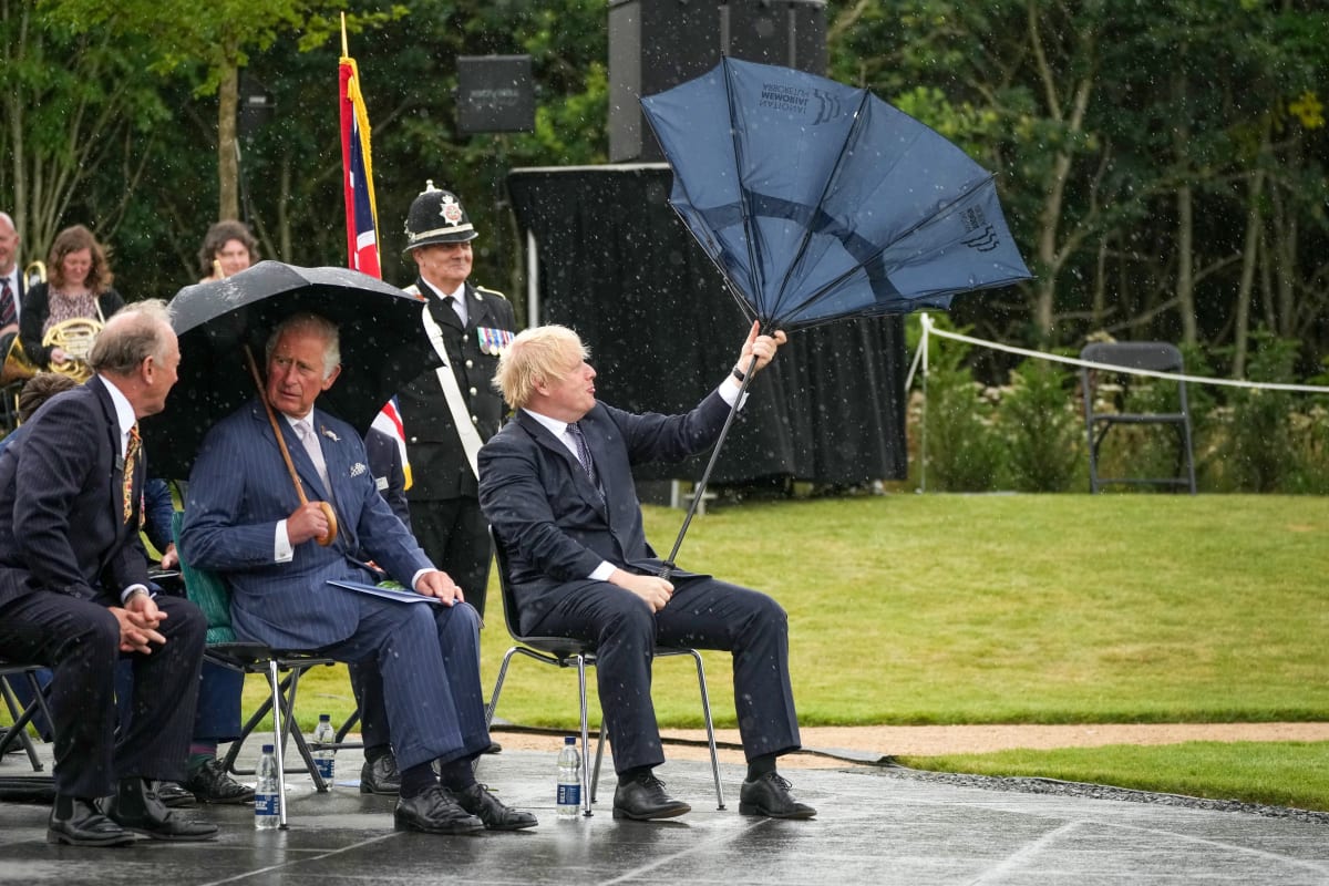 Boris Johnson zápasil na policejní slavnosti s deštníkem.
