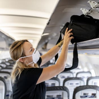 Žena, která cestuje v letadle a má respirátor