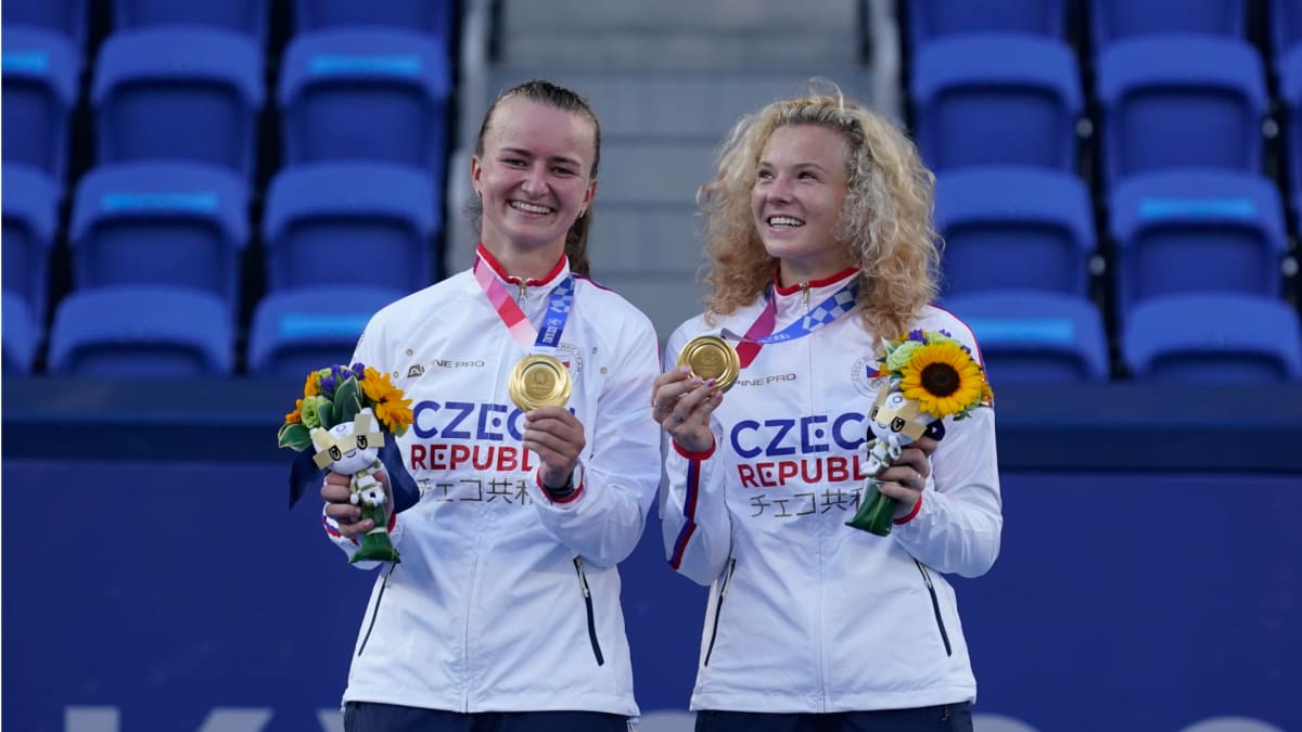 Barbora Krejčíková (vlevo) a Kateřina Siniaková slaví zlaté olympijské medaile z tenisové čtyřhry.