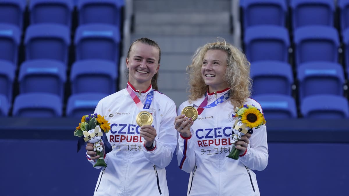 Barbora Krejčíková (vlevo) a Kateřina Siniaková slaví zlaté olympijské medaile z tenisové čtyřhry.