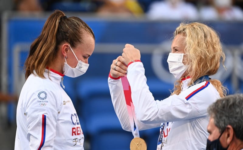 Kateřina Siniaková dává na krk zlatou olympijskou medaili své parťačce Barboře Krejčíkové.