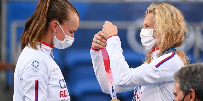 Kateřina Siniaková dává na krk zlatou olympijskou medaili své parťačce Barboře Krejčíkové.