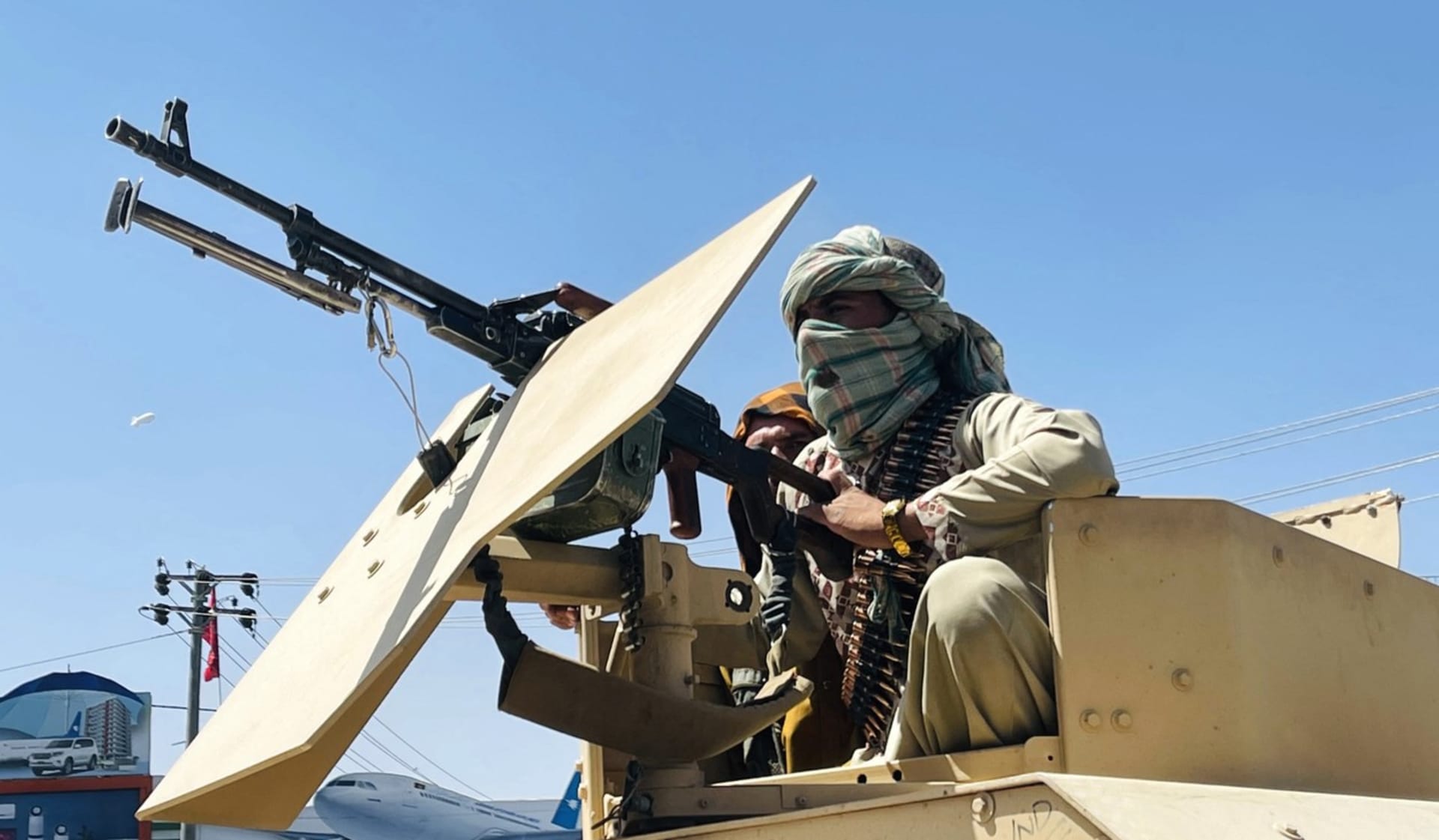 Tálibánský bojovník v kulometném hnízdě na obrněném voze.