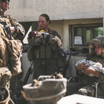 Fotografie, na níž seržantka Nicole Geeová (vlevo) drží afghánské dítě obletěl celý svět.