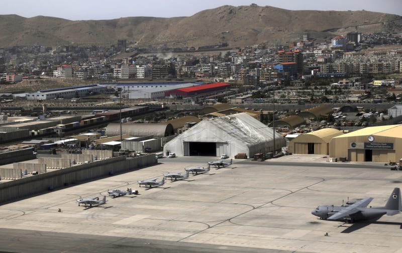 Letouny AC-208 a vojenský transportér C-130 Hercules na kábulském vojenském letišti.