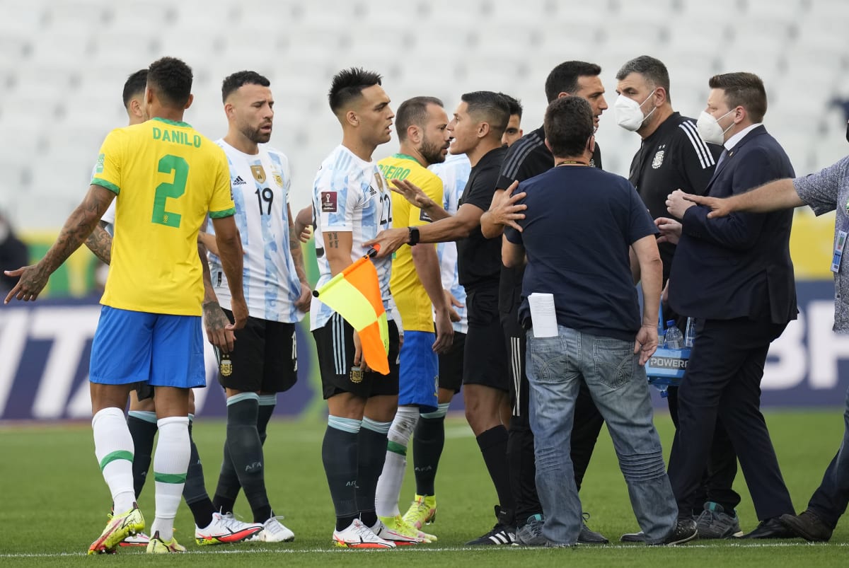 Rozhodčí uklidňuje argentinské fotbalisty kvůli přerušení kvalifikačního zápasu v brazilském So Paulu. 