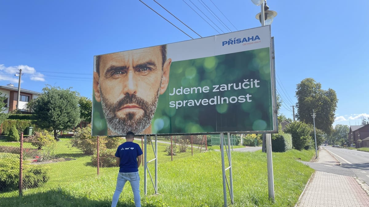 Radim Ivan alias Princ z ODS močí pod billboardem Roberta Šlachty.