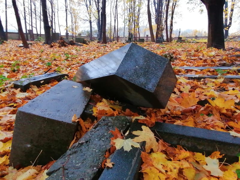 Povalené a polámané náhrobky na německém hřbitově v Krnově-Chomýži. Listopad 2020