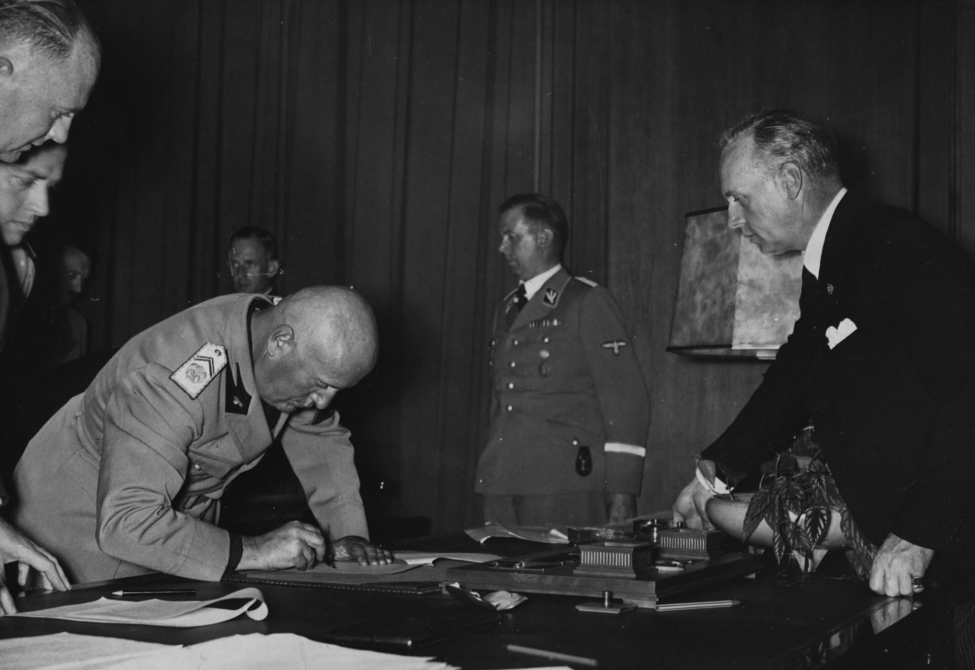 Italský fašista Benito Mussolini podepisuje Mnichovskou dohodu za přítomnosti německého ministra zahraničí Joachima von Ribbentropa.