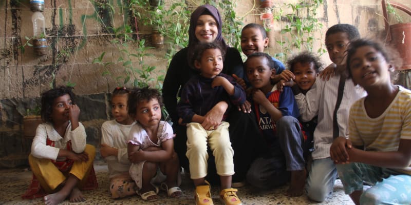 Sabina Addailamy (uprostřed mezi dětmi) pochází z Prahy. Na snímku s dětmi ve veřejné jídelně v jemenské městě San’á. 