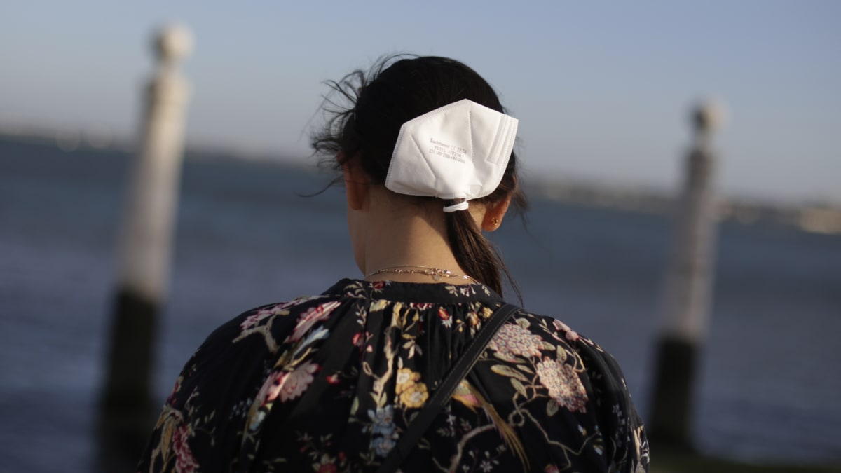 Dívka s respirátorem ve vlasech na břehu řeky Tajo v Lisabonu