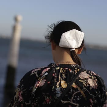 Dívka s respirátorem ve vlasech na břehu řeky Tajo v Lisabonu
