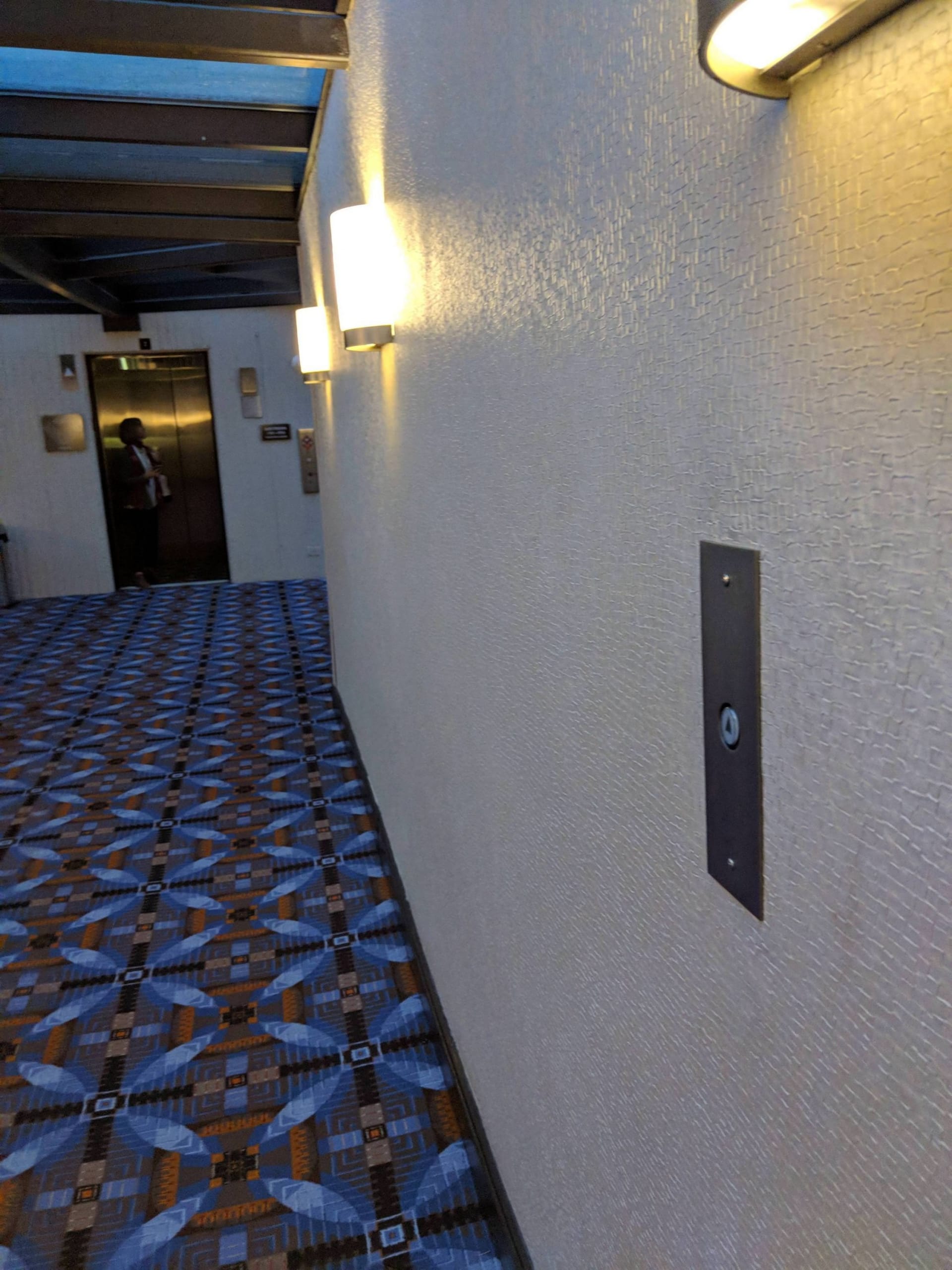 Výtahový čudlík uprostřed chodby. Než k němu přijdete, výtah bude u vás.