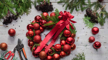 Věnec z vánočních ozdob a drátěného ramínka na šaty rozzáří dveře i stůl