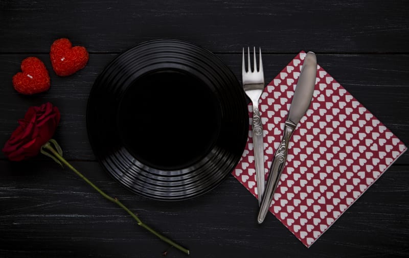 Valentýnská tabule: Pokud chcete letos zkusit něco neobvyklého nebo máte doma chlapa, který se u bílého ubrusu necítí zrovna nejlépe, můžete ho okouzlit dramatickou kombinací černé a červené.