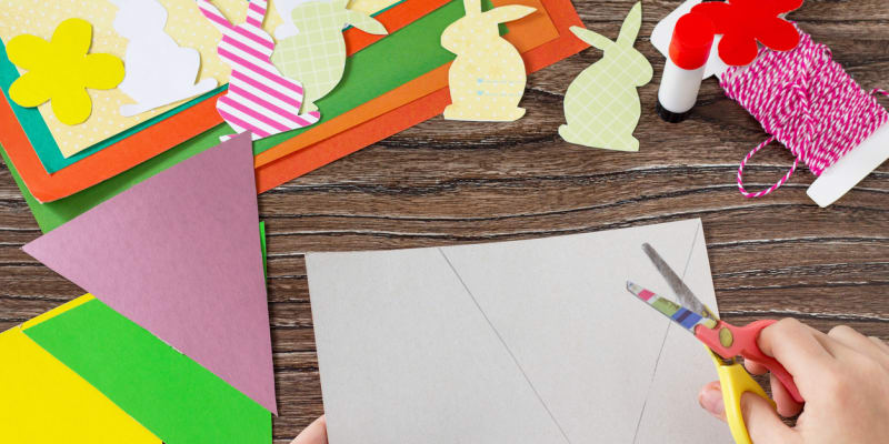 Vytvořte si s dětmi barevnou praporkovou girlandu: Podle pravítka narýsujte na barevné čtvrtky několik trojúhelníkových praporků a vystřihněte je.