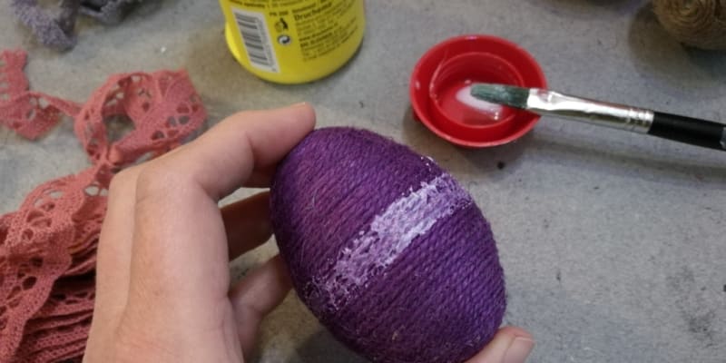 Velikonoční kraslice zdobené barveným lněným provázkem: V místě, kde budete nalepovat krajkovou ozdobu, natřete vajíčko lepidlem. 