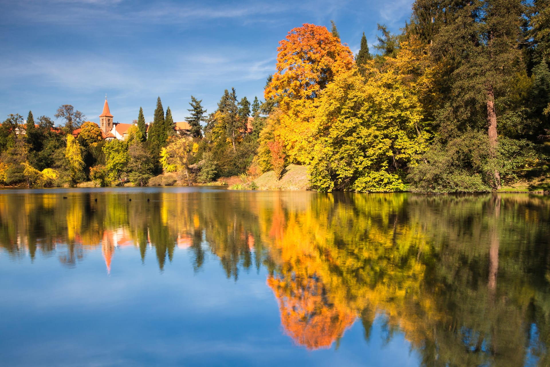 Nádherná podzimní příroda parku se dokonale odráží na hladině jezera