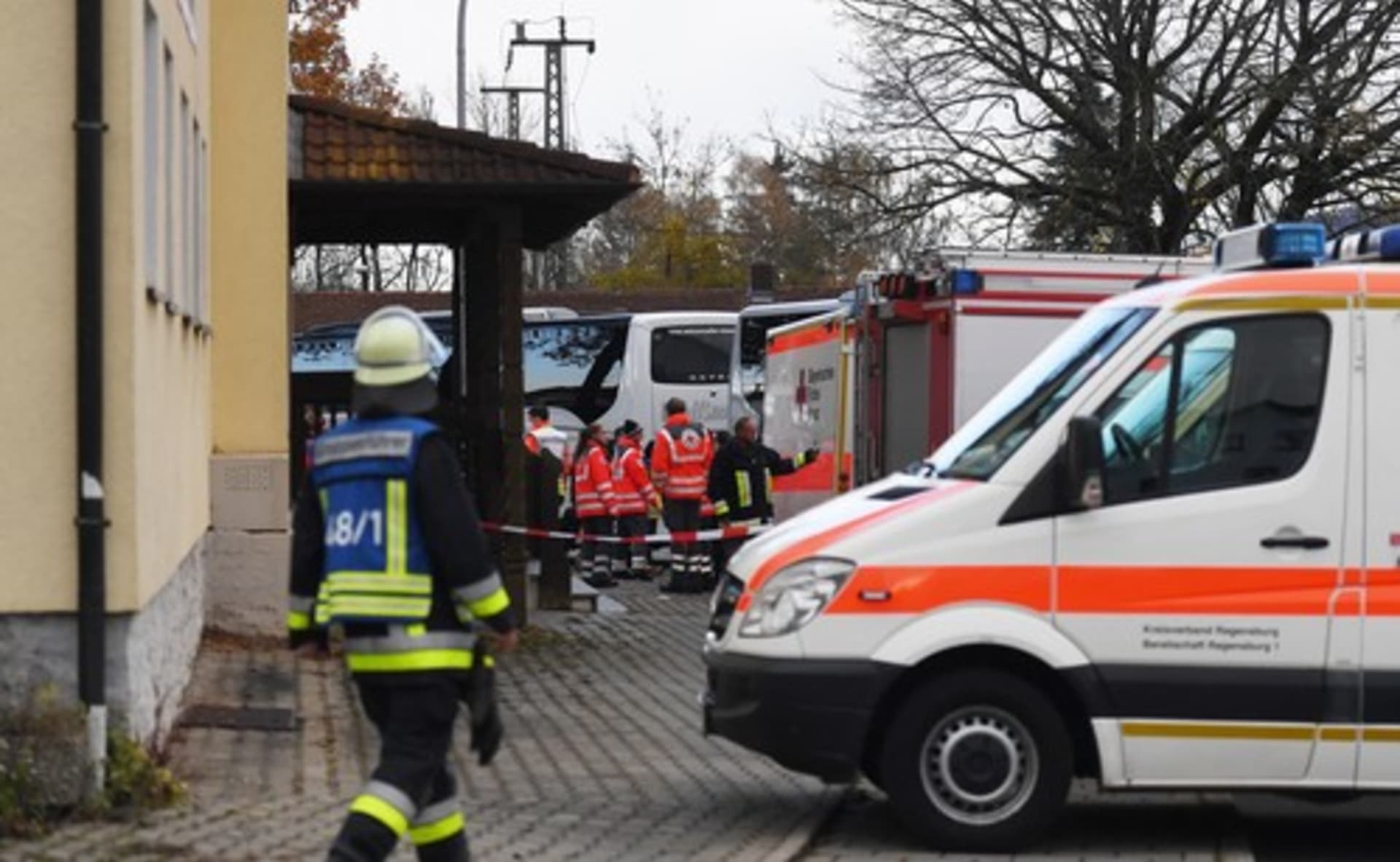 Záchranáři stojí před restaurací ve stanici Seubersdorf, kde byli po útoku shromážděni cestující z vlaku.
