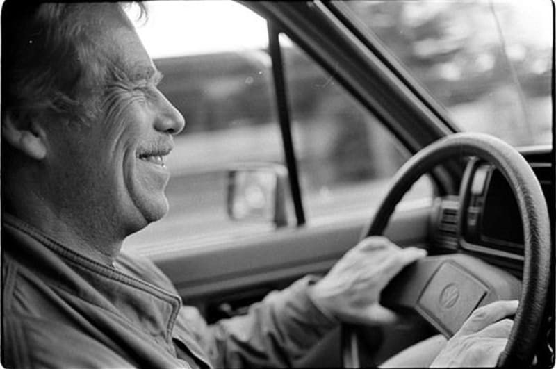 Václav Havel býval vášnivým řidičem a za svůj život vystřídal řadu zajímavých automobilů. Tento snímek od Bohdana Holomíčka jej zachycuje za volantem jeho Golfu v roce 1989.