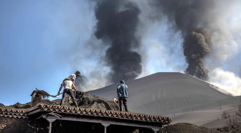 Lidé uklízejí popel po výbuchu sopky Cumbre Vieja na kanárském ostrově La Palma.