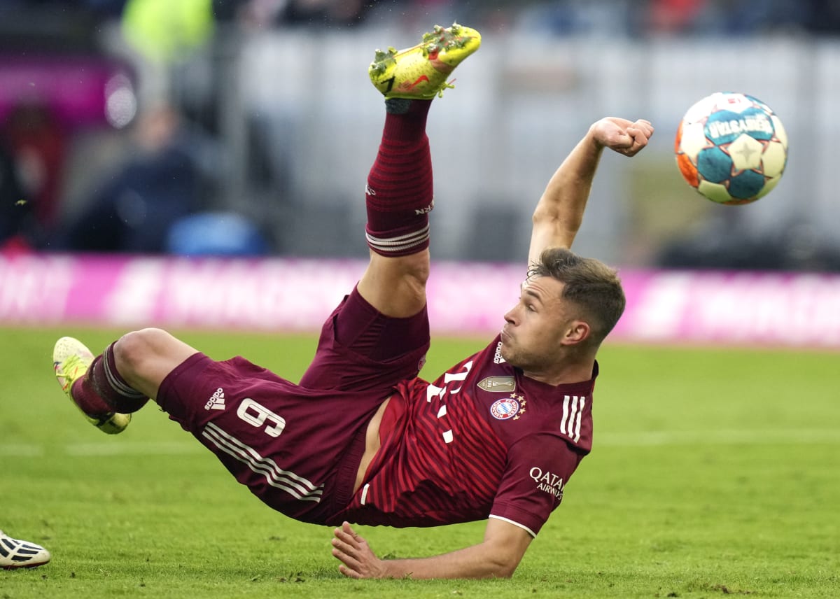 Joshua Kimmich z Bayernu Mnichov odkopává míč v poněkud nefotbalové poloze při svém posledním utkání před dvojnásobnou karanténou proti SC Freiburg v bundeslize.