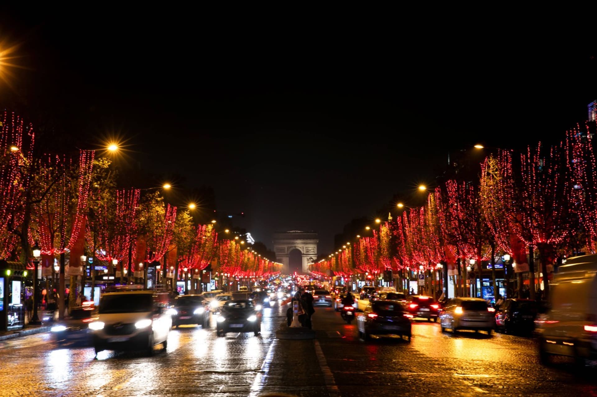 Nazdobené stromy a v dálce pařížský Vítězný oblouk