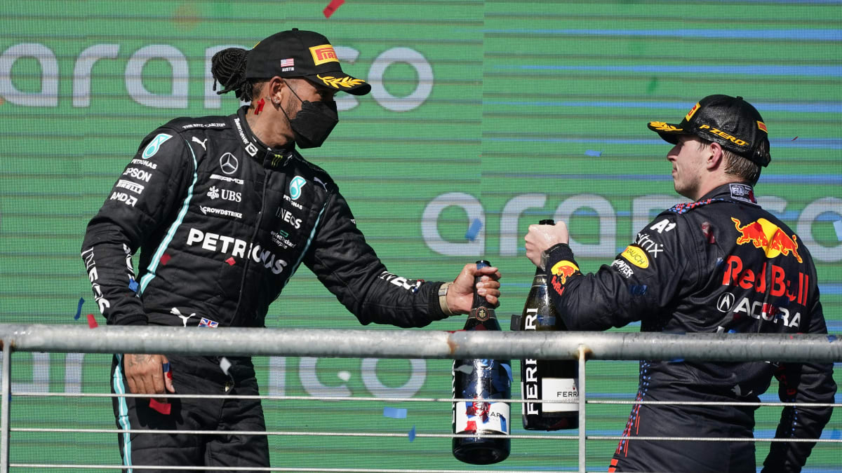 Přátelské ťuknutí šampaňským mezi Hamiltonem a Verstappenem nepřipomíná souboje na trati. Ty byly v končící sezoně často nelítostné.
