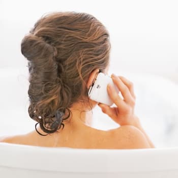 Dívka s telefonem ve vaně