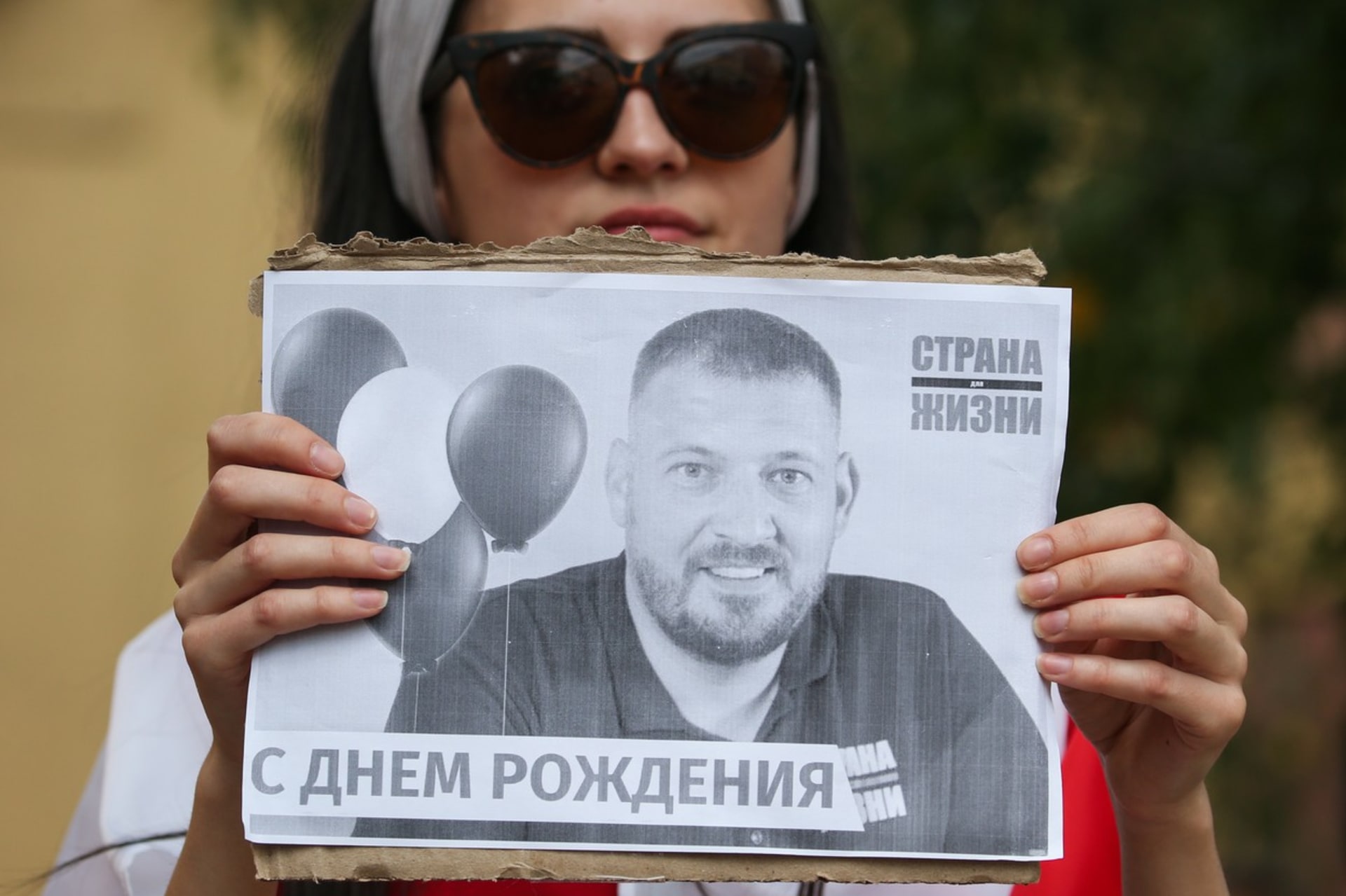 Demonstrantka drží podobiznu Sjarheje Cichanouského.