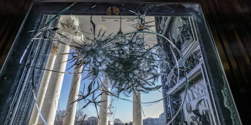 Rozbité dveře do budovy Kapitolu, které ještě týden po útoku připomínaly děsivé momenty.