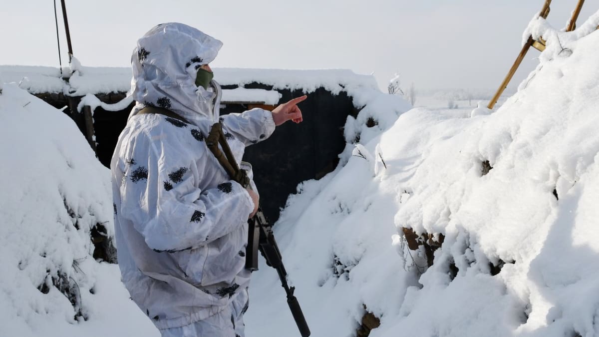 Ukrajinský voják na frontě hledí na území ovládané proruskými separatisty.