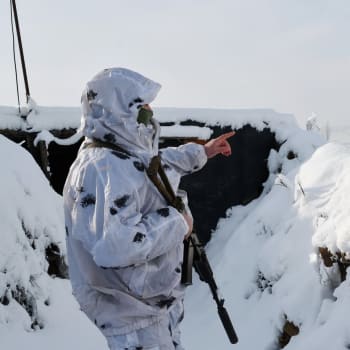 Ukrajinský voják na frontě hledí na území ovládané proruskými separatisty.