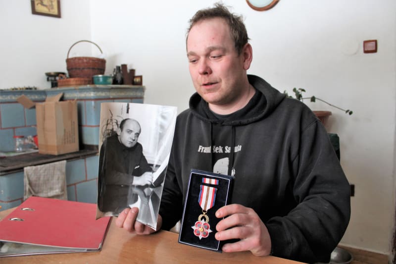 Aleš Plocek, vnuk upáleného Evžena Plocka. S fotkou dědy a vyznamenáním pro hrdinu, který se obětoval na protest proti ruské okupaci.