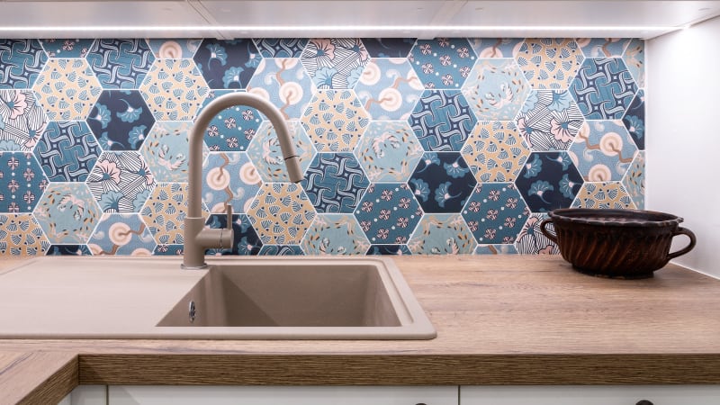 Jak se staví sen: mozaika s motivem různobarevného patchworku za kuchyňskou linkou