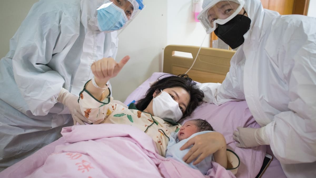 Žena se zdravým novorozenětem v porodnici v čínském Wu-chanu