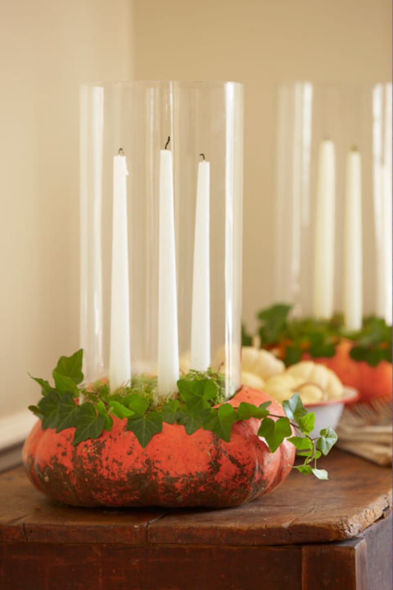 Ploché dýně se skvěle hodí k výrobě dekoračního věnce na stůl. Vršek seřízněte, ozdobte zelenými větvičkami a do dužniny zapíchněte svíčky.