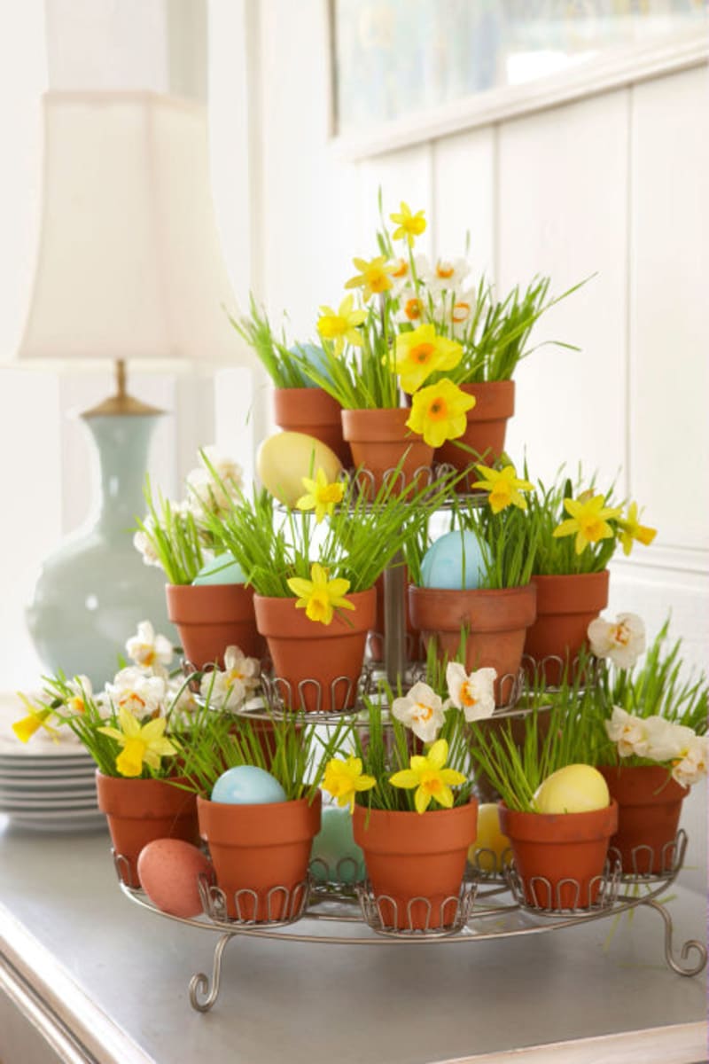 Místo květin ve váze stůl krásně ozdobí i pyramida z květináčků s jarním osením, malými narciskami a vajíčky.