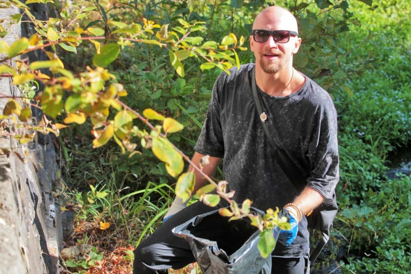 Tomáš Klus sbírá odpadky podél řeky s ekologickým hnutím