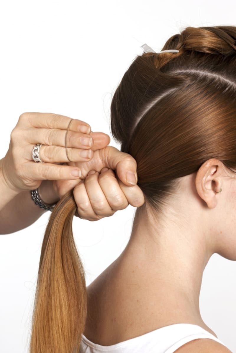 3.	Vlasy vzadu na hlavě stáhněte do dlaně. Použijte gumičku a vytvořte culík. Umístěte ho nízko nad krkem do středu hlavy.