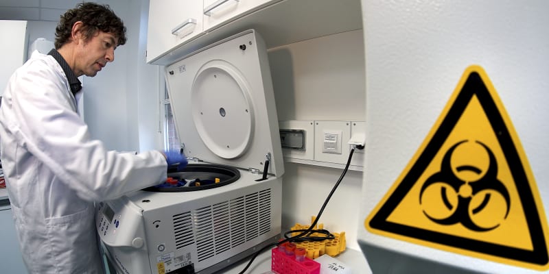 Německý virolog a poradce německé vlády Christian Drosten vkládá materiál od testovacího zařízení v berlínské nemocnici Charité.