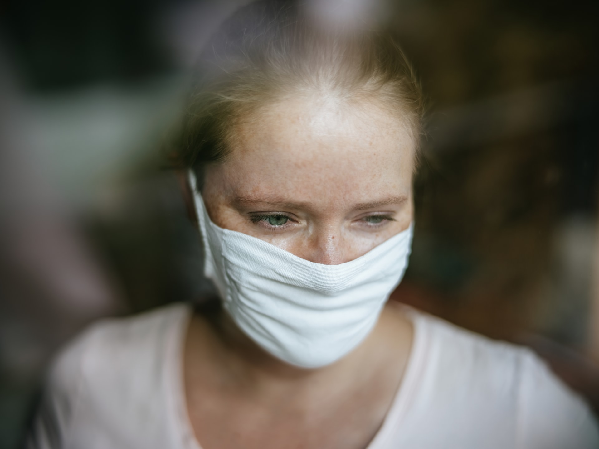 Žena za oknem s respirátorem (ilustrační foto)